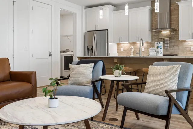 a kitchen with stainless steel appliances kitchen island granite countertop a dining table and chairs