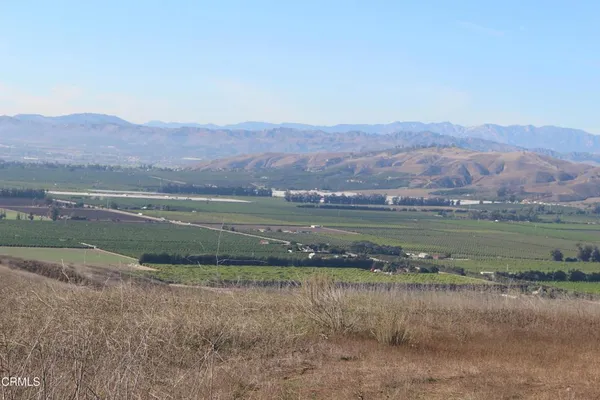 an aerial view of residential houses with outdoor space and lake view
