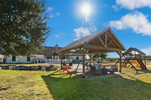 a view of a swimming pool with lawn chairs and a yard