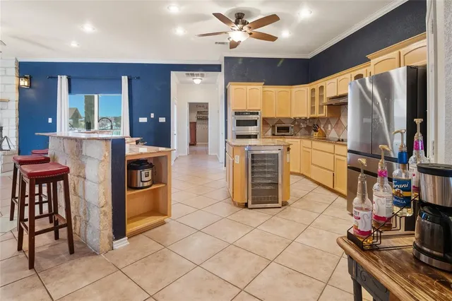 a kitchen with stainless steel appliances granite countertop a stove top oven a refrigerator and a dining table with wooden floor