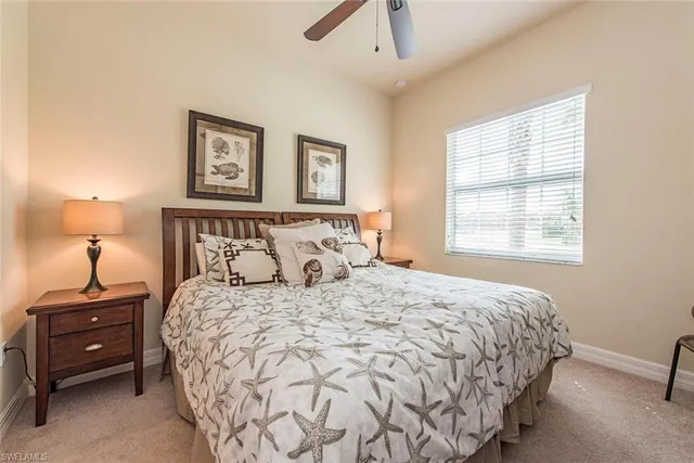 a bedroom with a bed a painting on the wall and a window