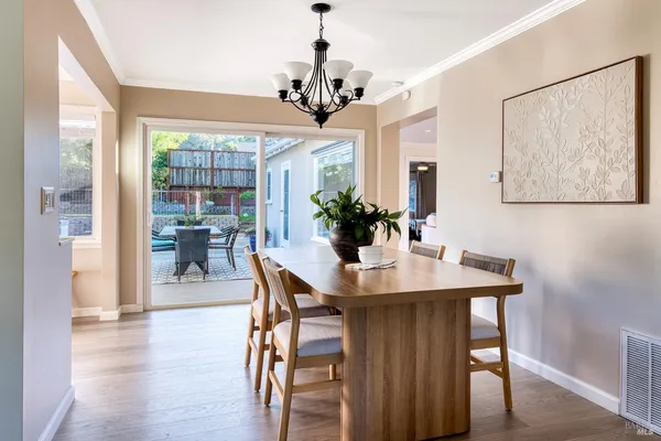 a view of a dining room with furniture wooden floor and chandelier