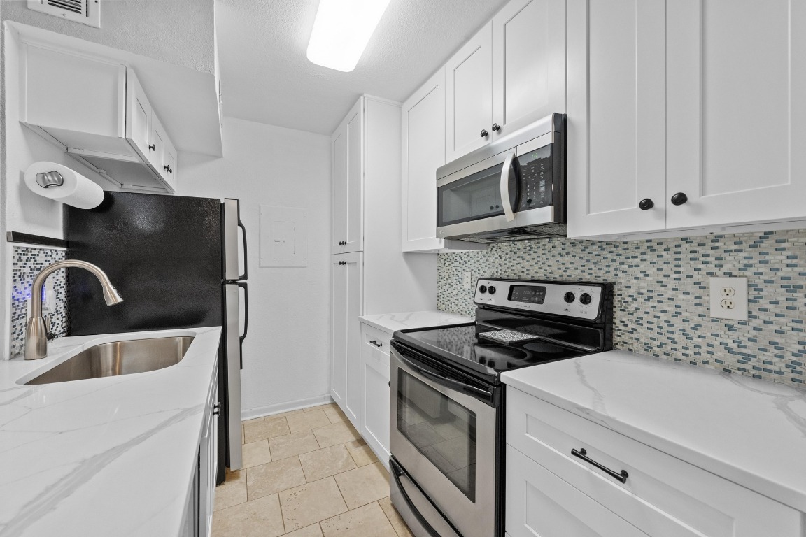 3204 Menchaca Road, Unit 405 Austin, TX 78704 - Photo 2 of 29 a kitchen with stainless steel appliances granite countertop a sink stove and microwave