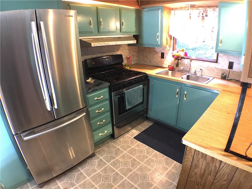 149 Fry Hollow Road Hunker, PA 15639 - Photo 11 of 22 Updated kitchen features stainless steel appliances & sink, gas stove with range hood, nice counter space, pantry, broom closet and contemporary vinyl floor. Window over sink overlooks the hillside.