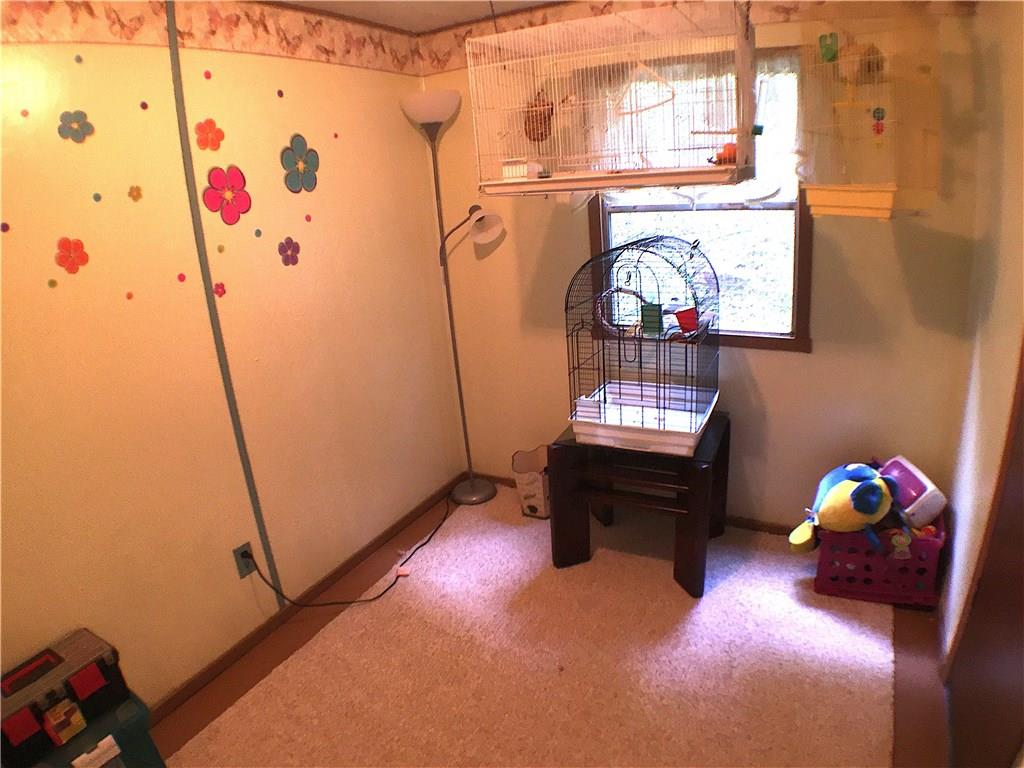 149 Fry Hollow Road Hunker, PA 15639 - Photo 20 of 22 Bedroom #2. Has a neutral color scheme, newer floor rug and bright/cheery window. Shares Jack & Jill toilet/sink bath with bedroom #3. Closet.