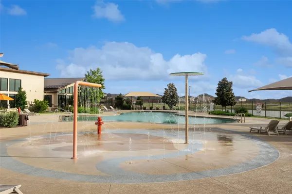 a view of a swimming pool with lawn chairs under an umbrella