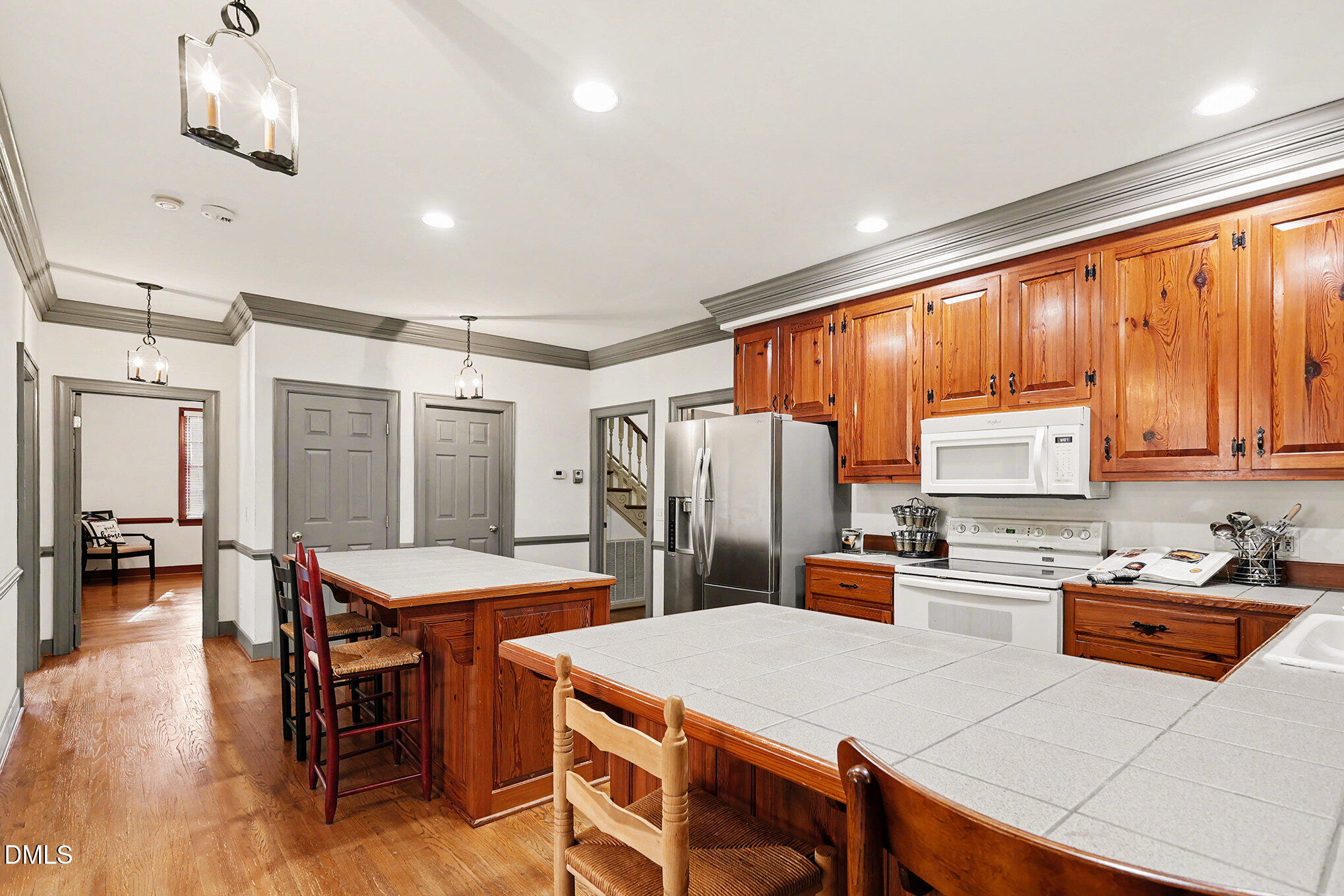 4604 Bartwood Drive Raleigh, NC 27613 - Photo 11 of 38 a kitchen with stainless steel appliances wooden floor dining table and chairs