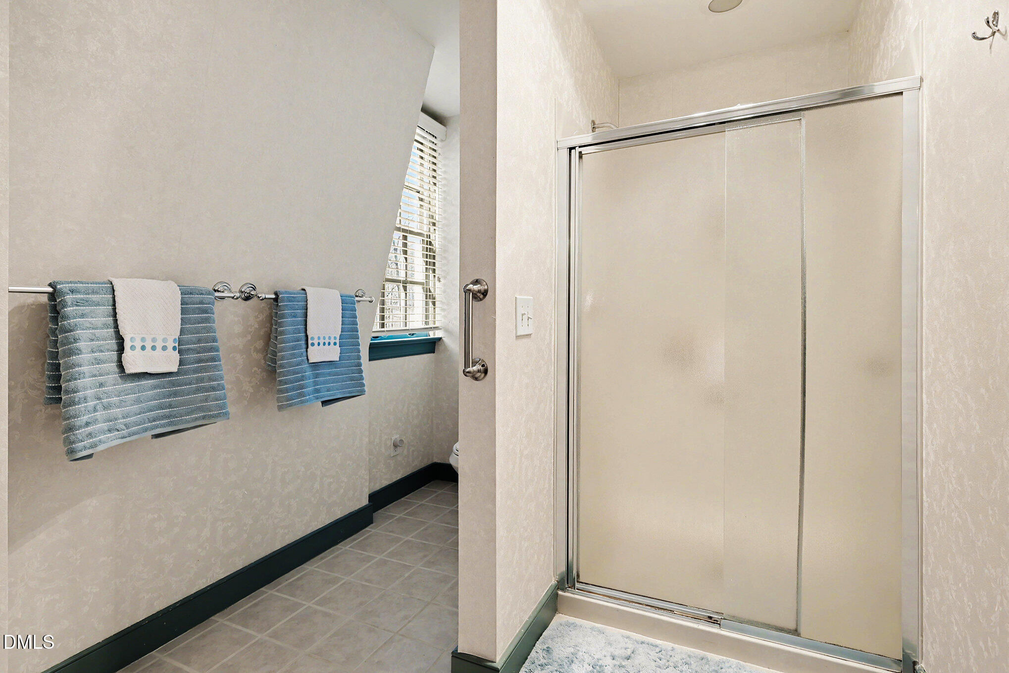 4604 Bartwood Drive Raleigh, NC 27613 - Photo 18 of 38 a bathroom with a shower and a window