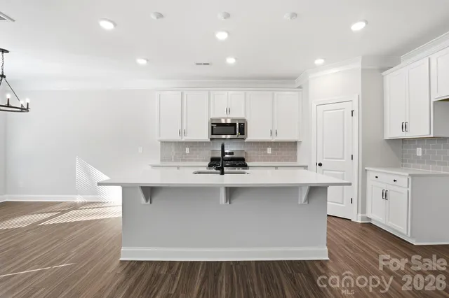 a kitchen with kitchen island sink stove and cabinets
