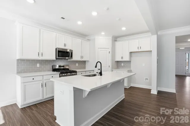 a kitchen with white cabinets stainless steel appliances and sink
