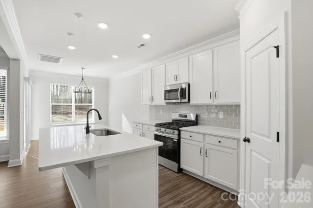 a kitchen with stainless steel appliances granite countertop a sink stove and cabinets