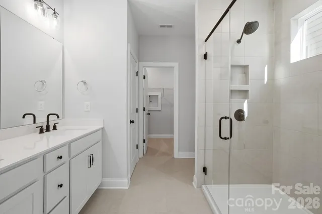 a bathroom with a shower sink and mirror