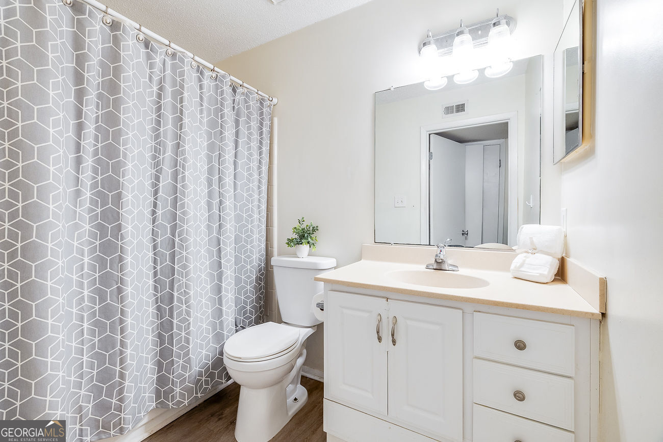 401 North Cromwell Road, Unit Q7 Savannah, GA 31410 - Photo 21 of 21 a bathroom with a toilet a sink and a mirror