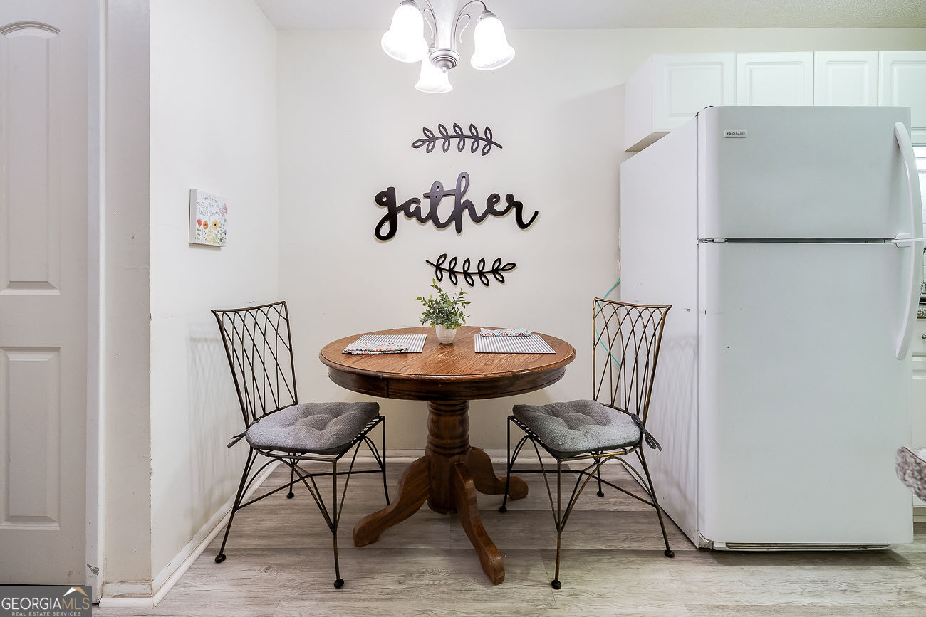 401 North Cromwell Road, Unit Q7 Savannah, GA 31410 - Photo 6 of 21 a view of a dining room with furniture a chandelier and wooden floor