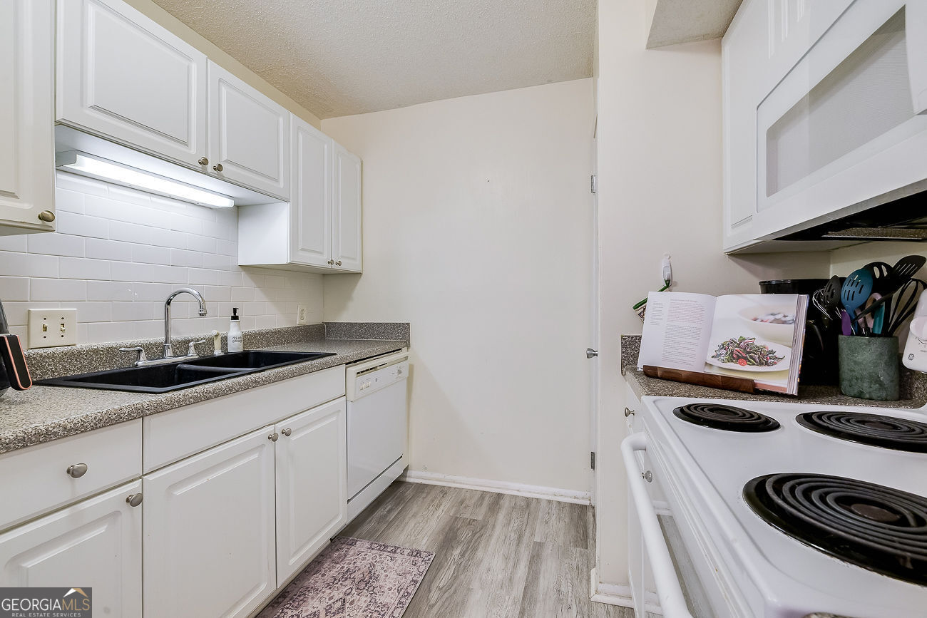 401 North Cromwell Road, Unit Q7 Savannah, GA 31410 - Photo 10 of 21 a kitchen with granite countertop stainless steel appliances a sink a stove and cabinets