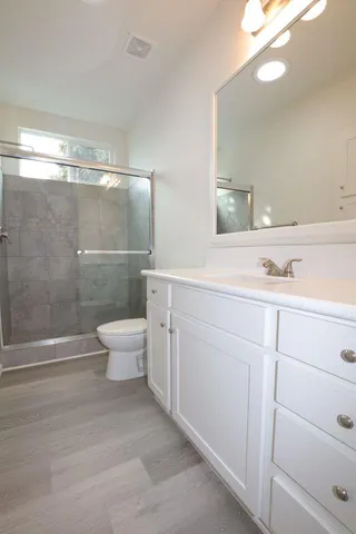 a bathroom with a sink a toilet and shower