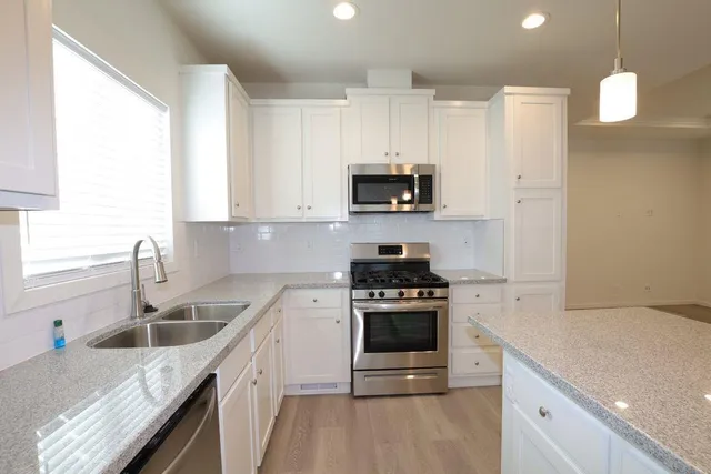 a kitchen with a sink a stove and oven