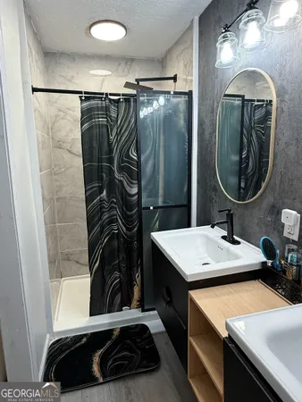 a bathroom with a sink a mirror and a shower