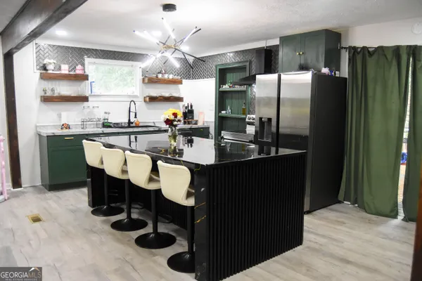 a kitchen with refrigerator and chairs