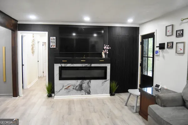 a living room with stainless steel appliances kitchen island furniture and a flat screen tv