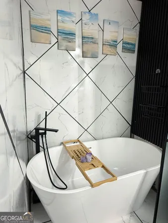 a white bath tub sitting next to a white wall