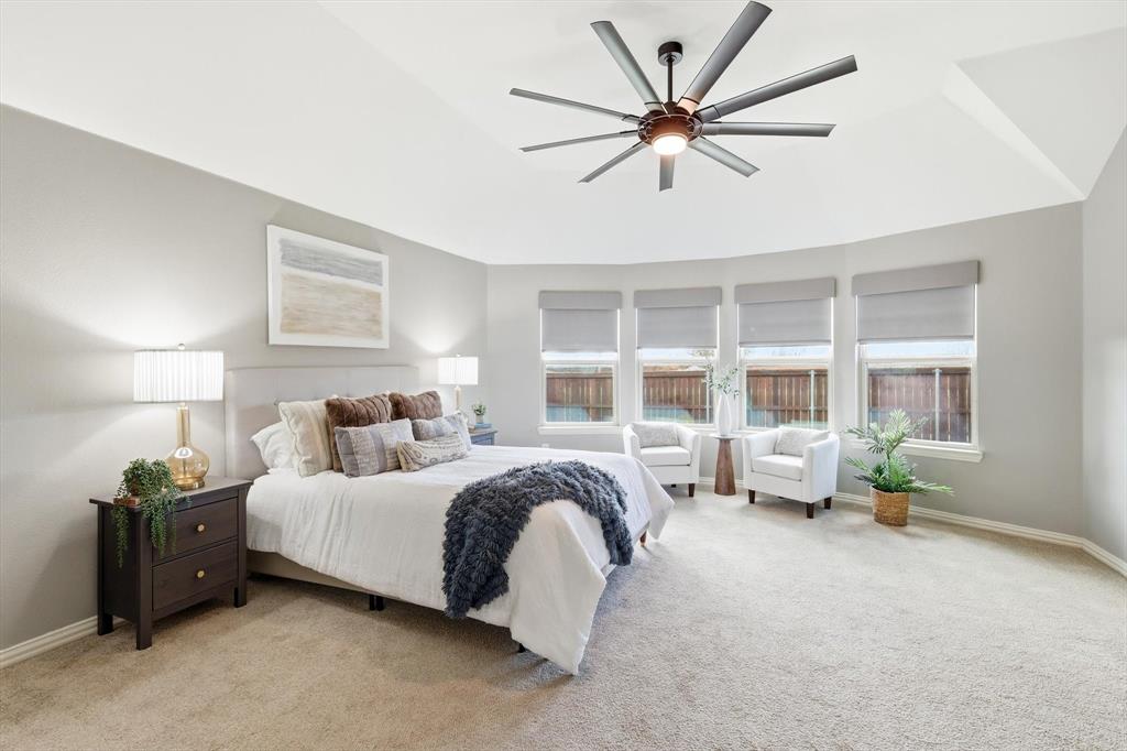 9728 Bitterroot Drive Little Elm, TX 75068 - Photo 17 of 39 LARGE private primary bedroom with seating area, large fan, norman shades, natural light and ensuite bathroom