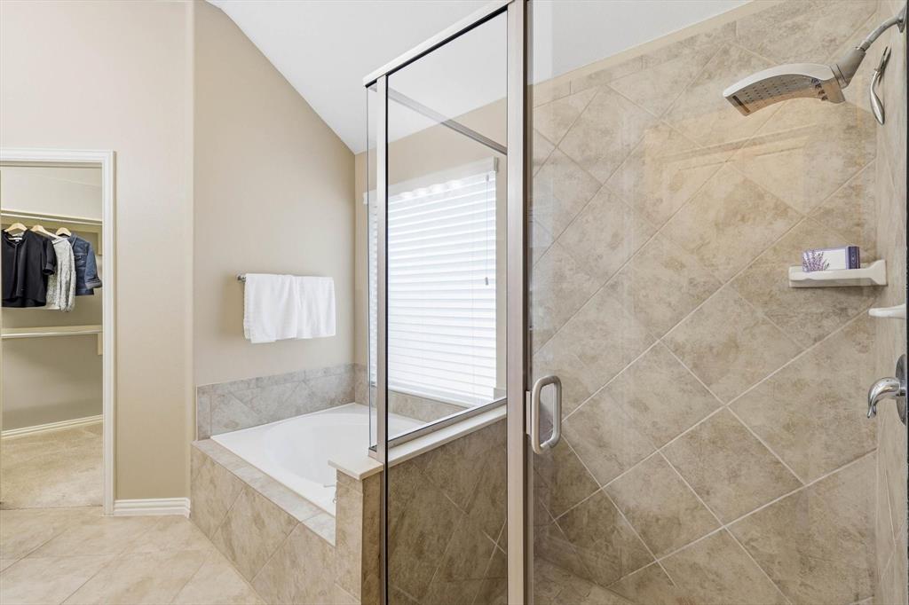 9728 Bitterroot Drive Little Elm, TX 75068 - Photo 23 of 39 Bathroom featuring a shower stall, a bath, vaulted ceiling, a walk in closet, and light tile patterned flooring