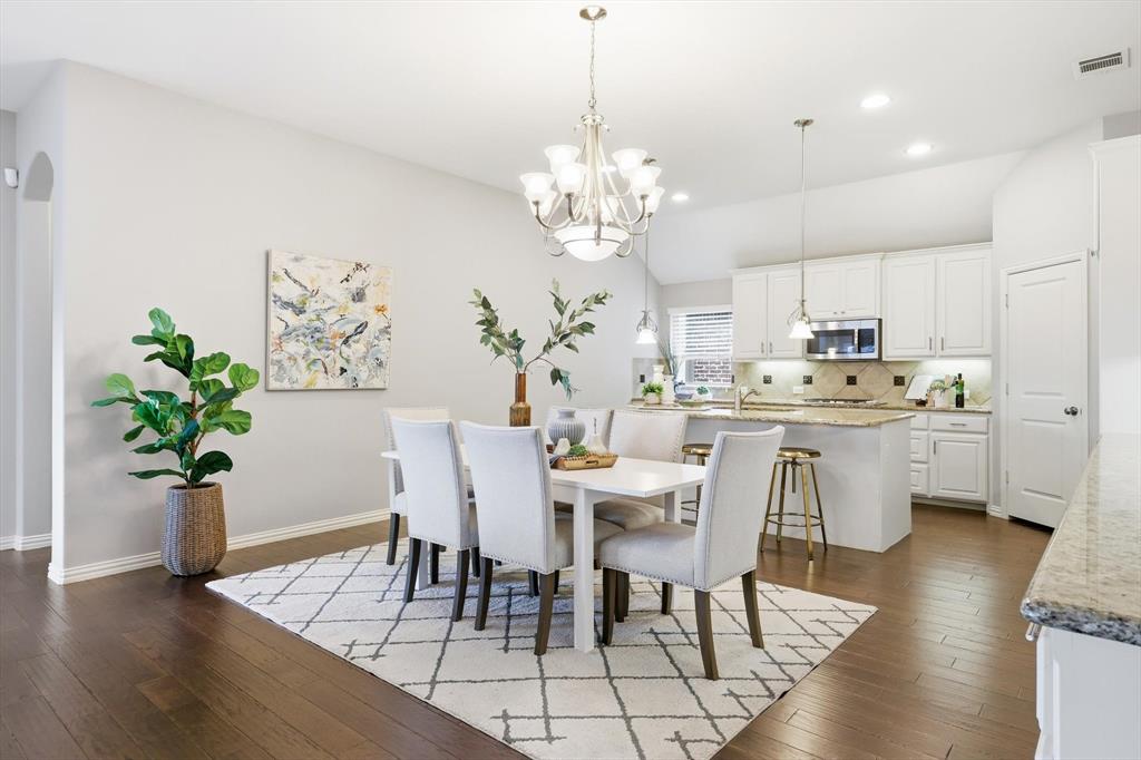 9728 Bitterroot Drive Little Elm, TX 75068 - Photo 9 of 39 Open Concept dining space splitting the kitchen and the living with ample storage, & counterspace.