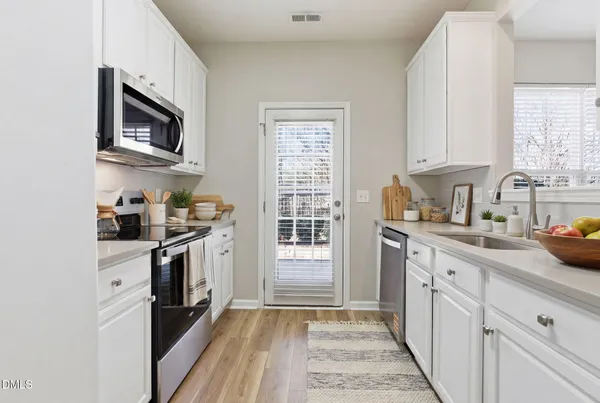 a kitchen with granite countertop a sink stove and refrigerator