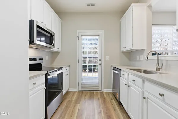 a kitchen with stainless steel appliances granite countertop a stove a sink and a refrigerator