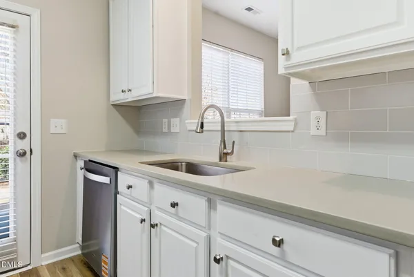 a kitchen with white cabinets and a sink