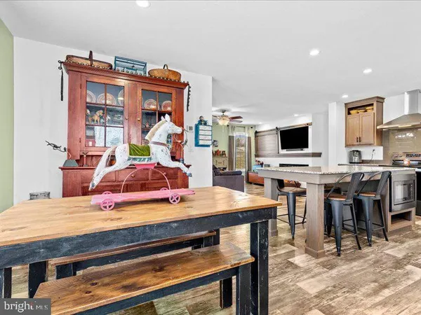 a kitchen with stainless steel appliances kitchen island granite countertop a table chairs and a refrigerator