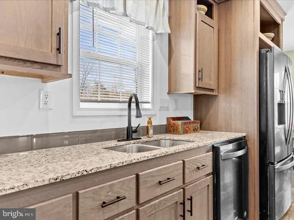 a kitchen with granite countertop kitchen island stainless steel appliances a sink window and cabinets