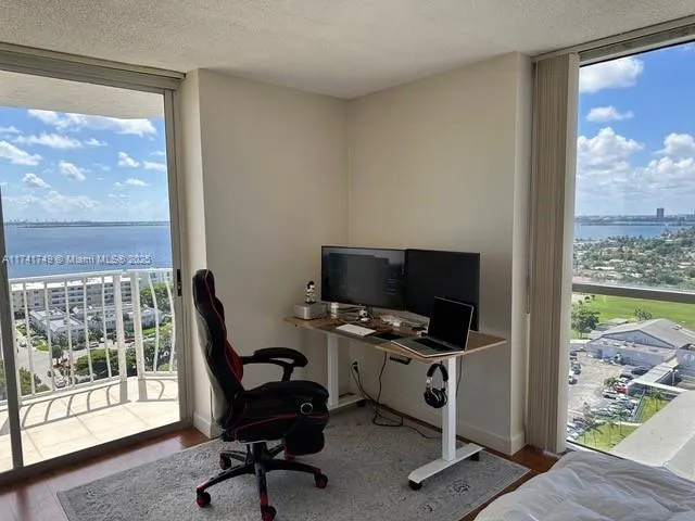 a view of a workspace with furniture and a window