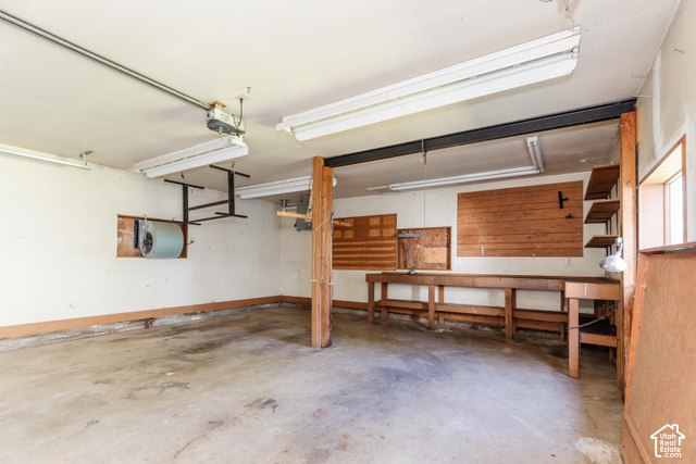 3959 Main Street Logan, UT 84321 - Photo 31 of 35 Concrete flooring garage with exposed wood support beams and built-in wood shelving