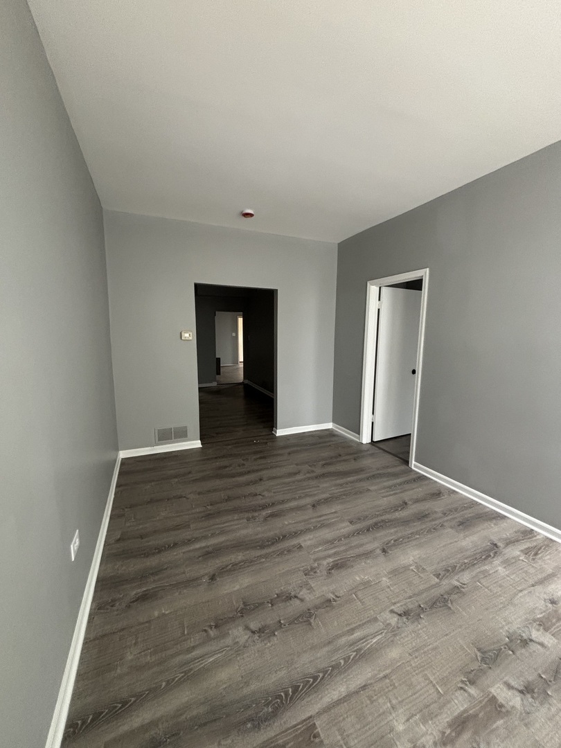 10401 South Ewing Avenue, Unit 104032 Chicago, IL 60617 - Photo 5 of 10 a view of an empty room with wooden floor and a window