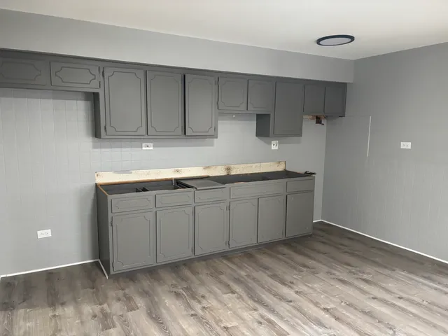 a kitchen with a sink cabinets and wooden floor