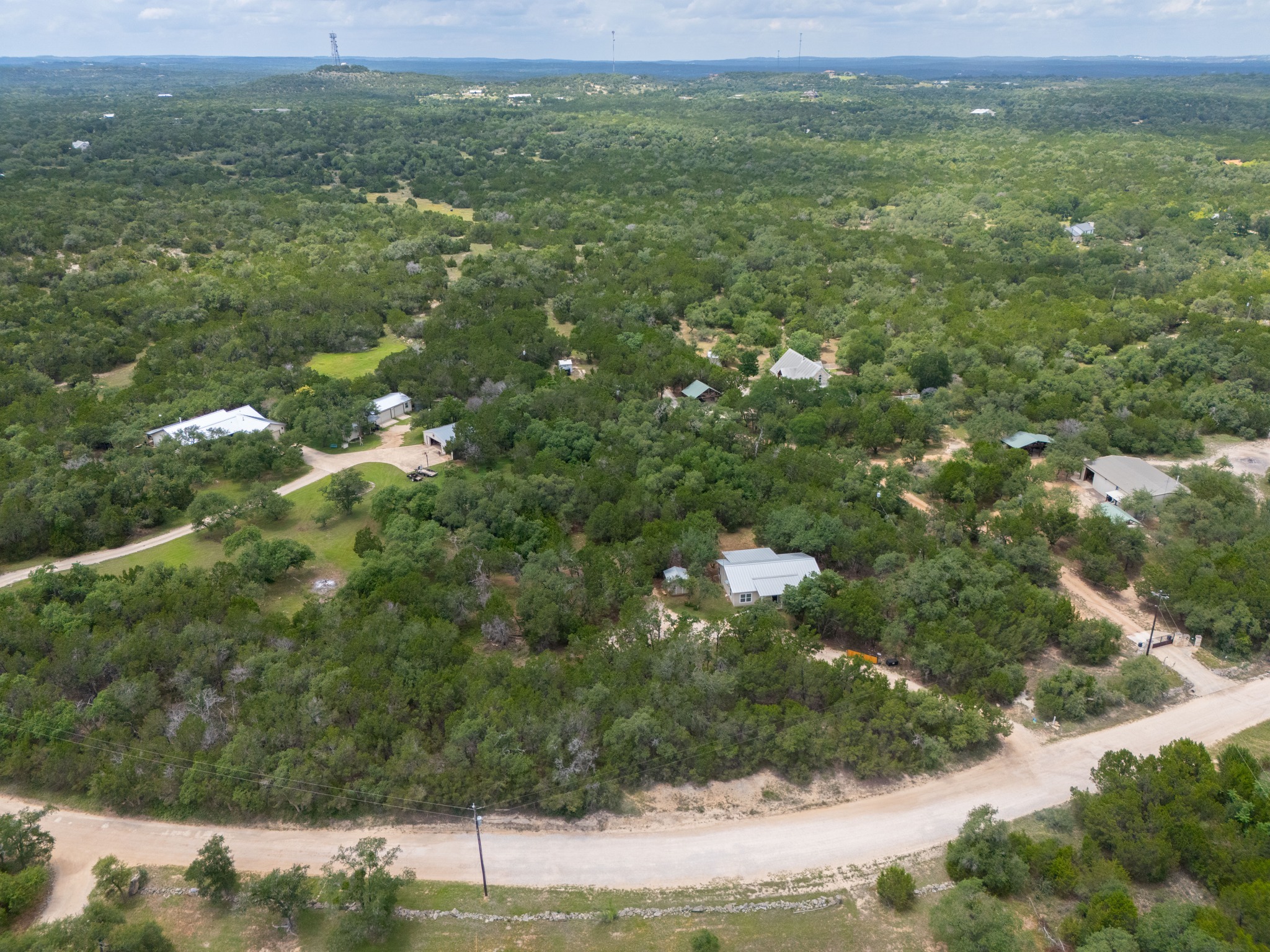 231 North Rainbow Ranch Road Wimberley, TX 78676 - Photo 35 of 40 Vast, verdant landscape surrounds a cluster of homes, hinting at tranquil, secluded living.