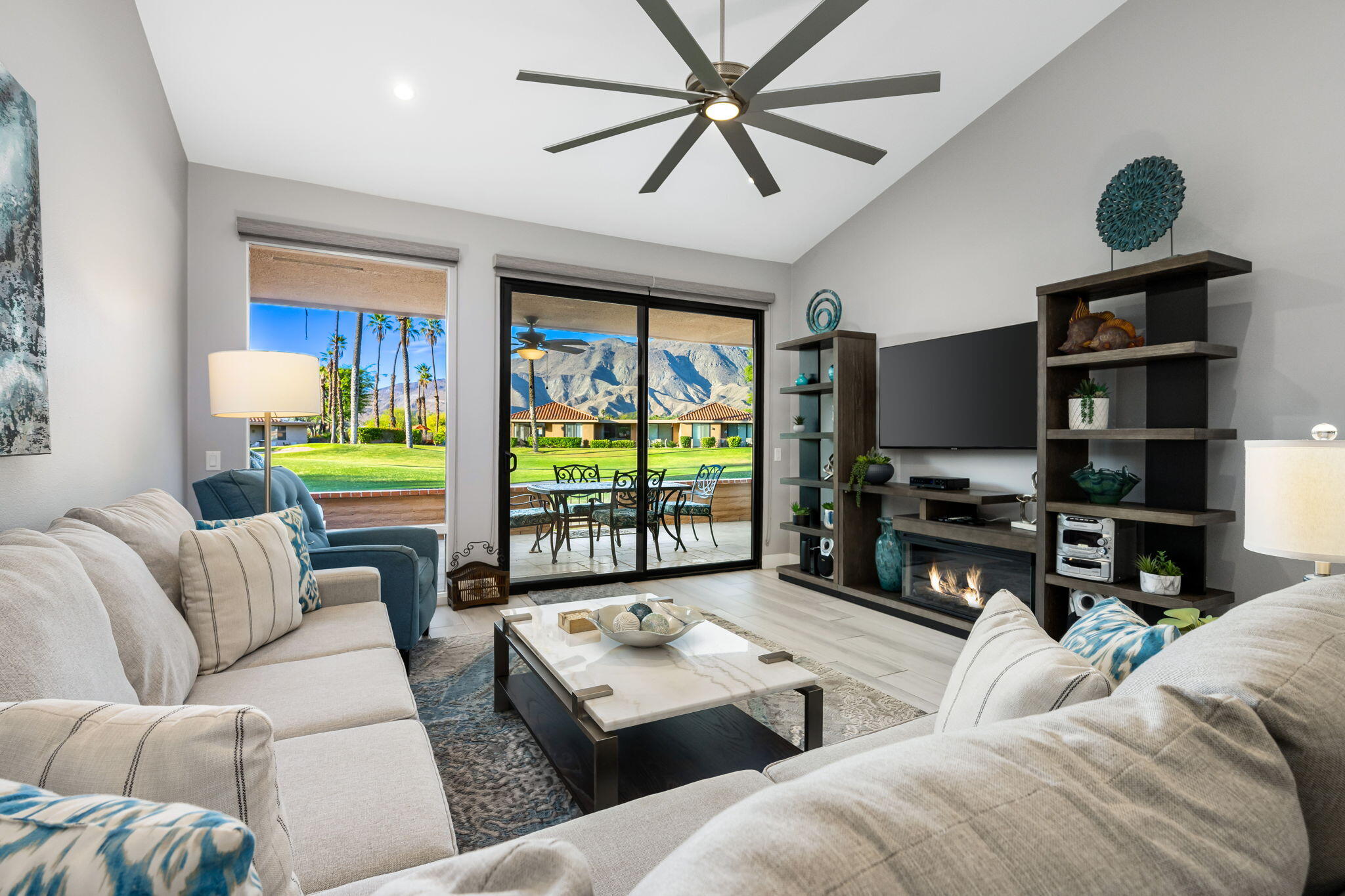 a living room with furniture a ceiling fan and a flat screen tv