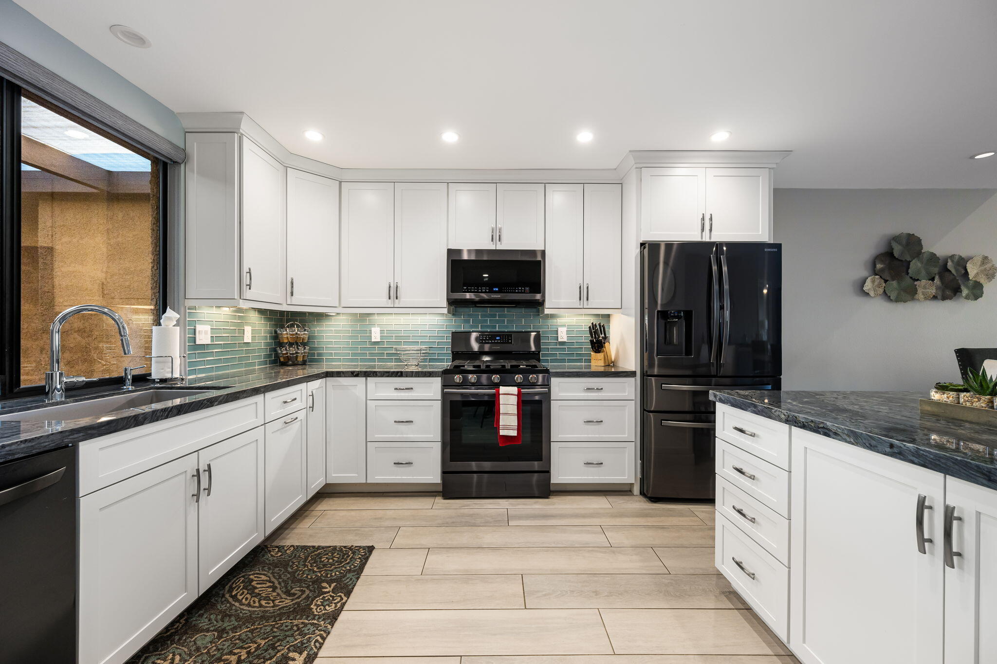 10 Palma Drive Rancho Mirage, CA 92270 - Photo 19 of 51 a kitchen with white cabinets and stainless steel appliances