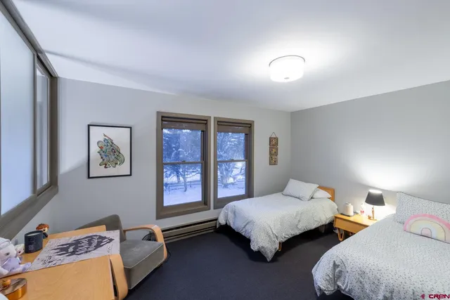 a bedroom with two beds and painting on the wall