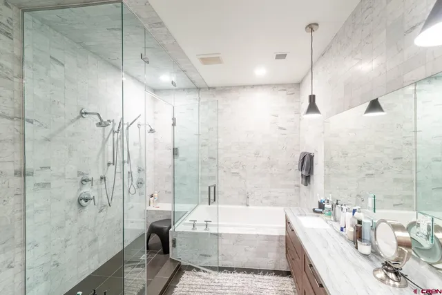 a spacious bathroom with a granite countertop sink a bathtub and shower