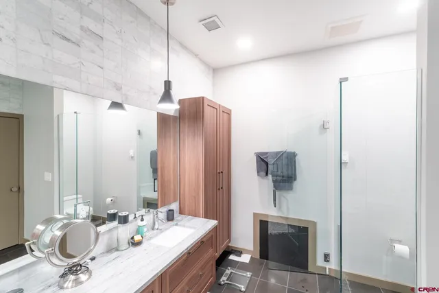 a bathroom with a sink a shower and a mirror