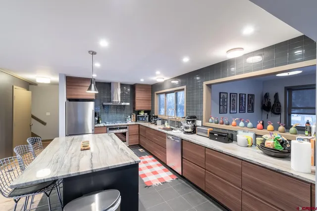 a kitchen with stainless steel appliances granite countertop sink stove refrigerator and cabinets