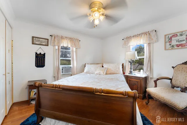 a bed sitting in a bedroom next to a window with a bookshelf