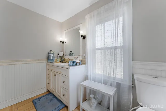 a bathroom with a sink a toilet and a window
