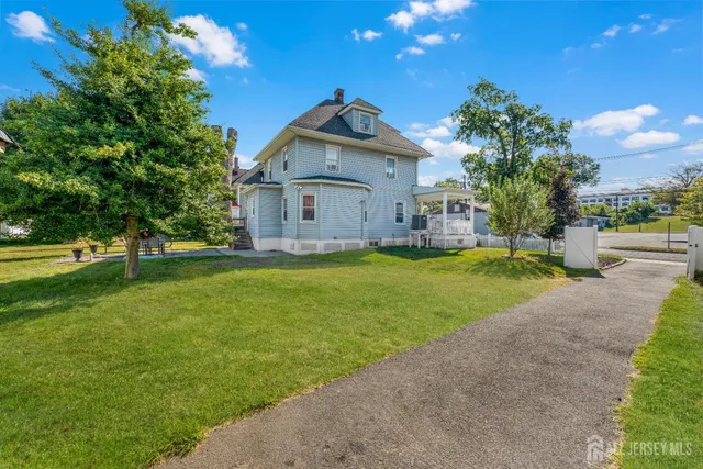 a front view of a house with a yard and trees