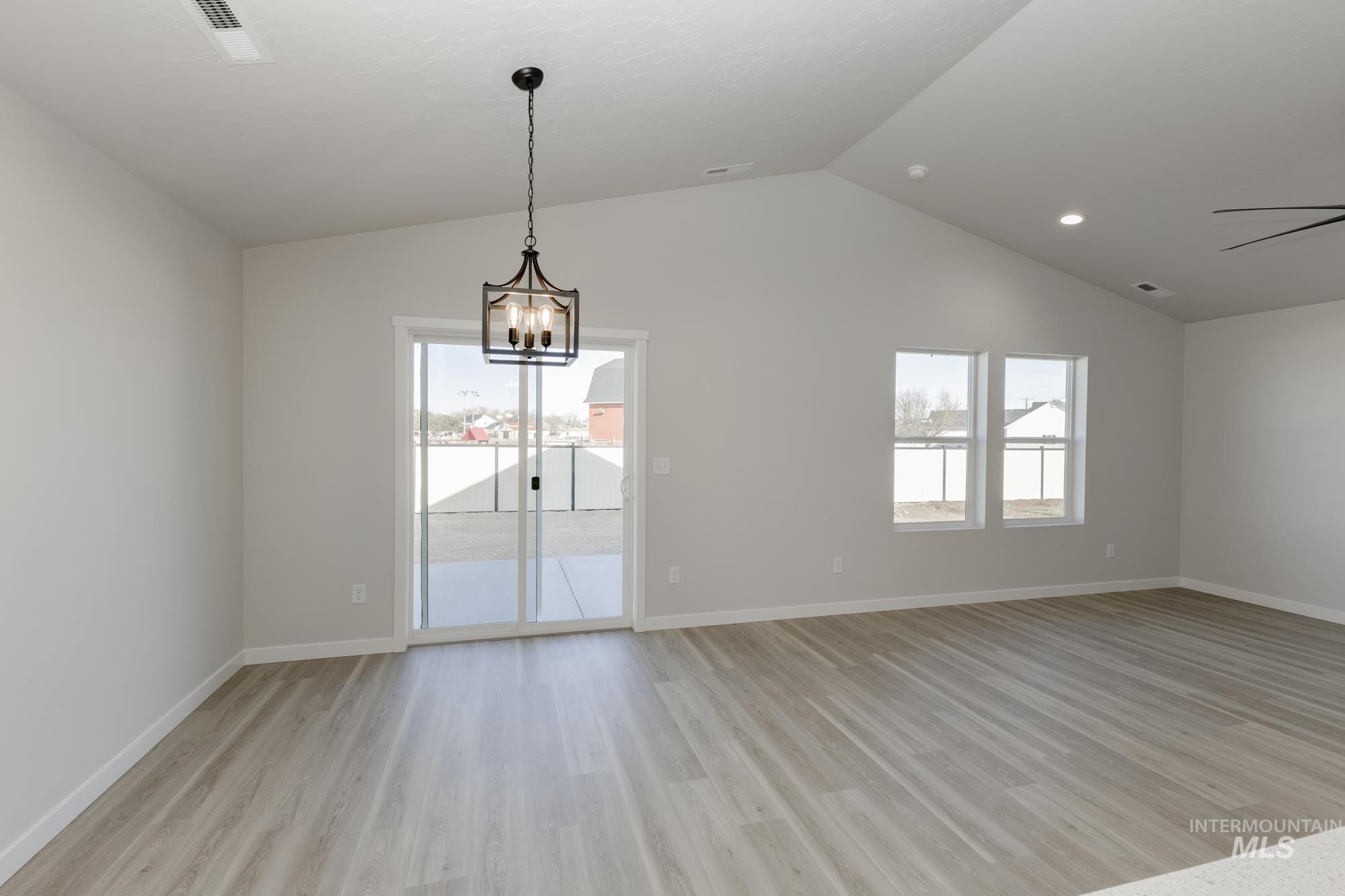 13337 Scrape Street Caldwell, ID 83607 - Photo 15 of 19 Vaulted ceilings, wood-finish flooring, two window openings, and a sliding glass door with a patio
