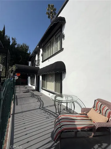 a view of a roof deck with table and chairs a barbeque