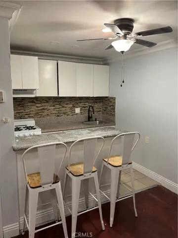 a kitchen with a dining table chairs and white cabinets